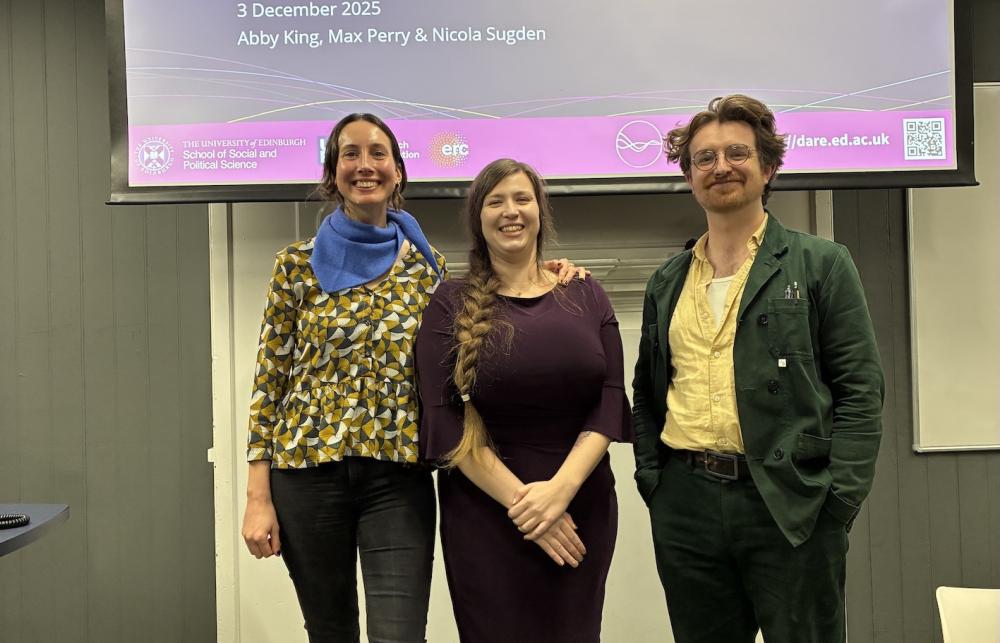 DARE Postdocs, Abby, Nicola, and Max (left to right) standing in front of their presentation title slide.